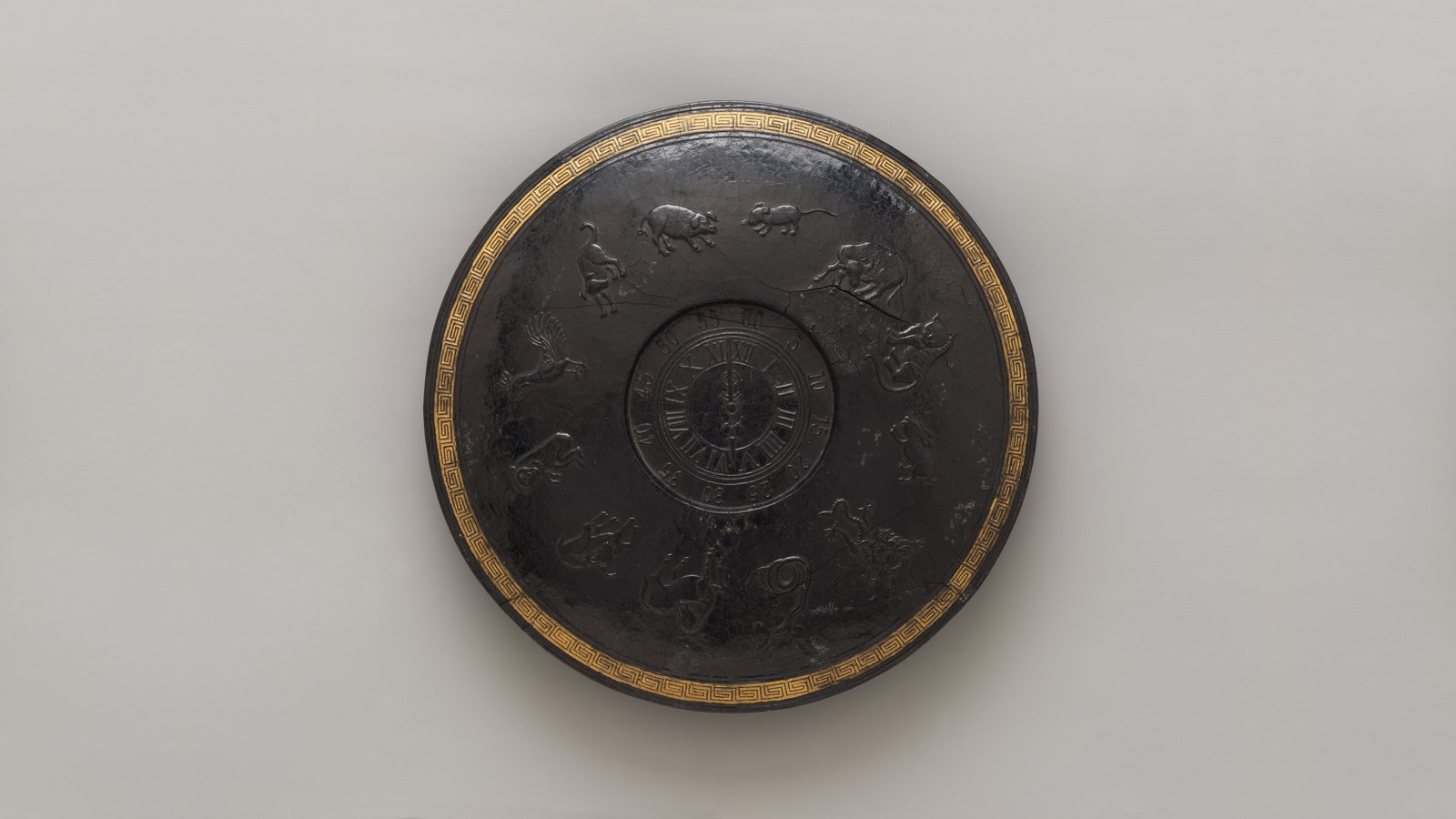 A round Chinese ink cake with a gilded border, its outer ring carved with the twelve zodiac animals and its inner medallion with the characters of the sexagenary cycle